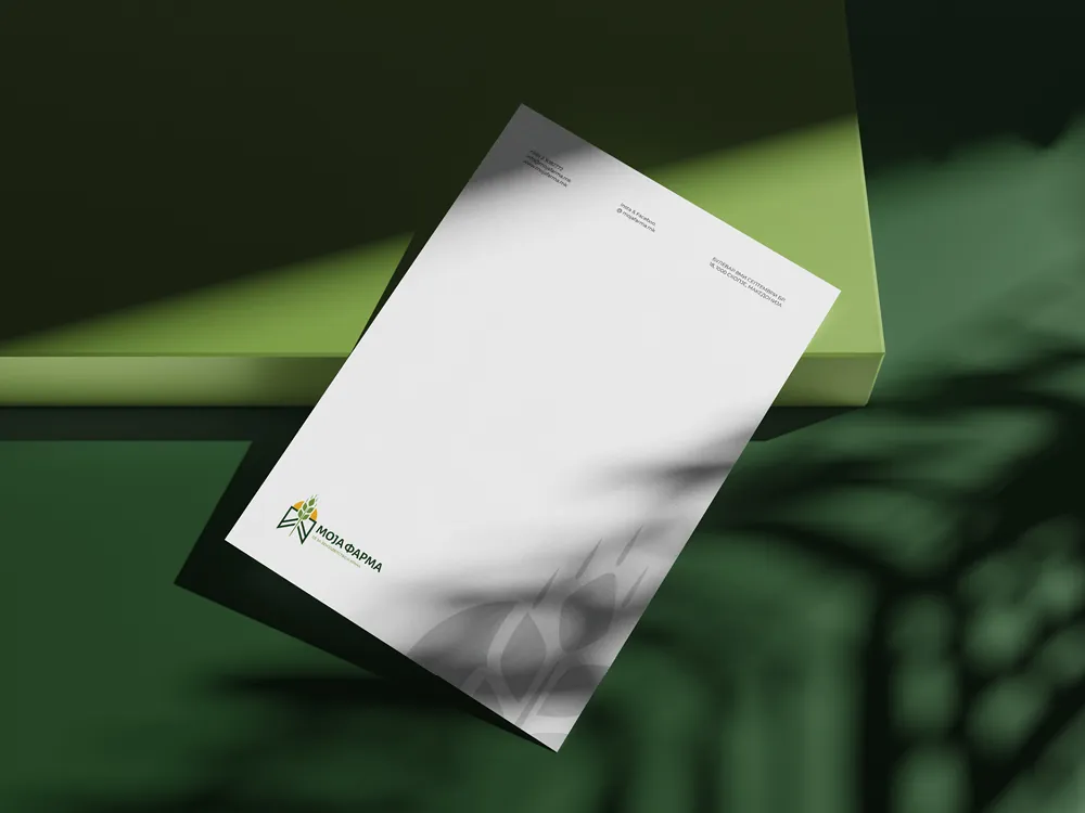 Moja Farma letterhead with the logo, contact details and a large faded wheat ear watermark, on a green set with leaf shadows